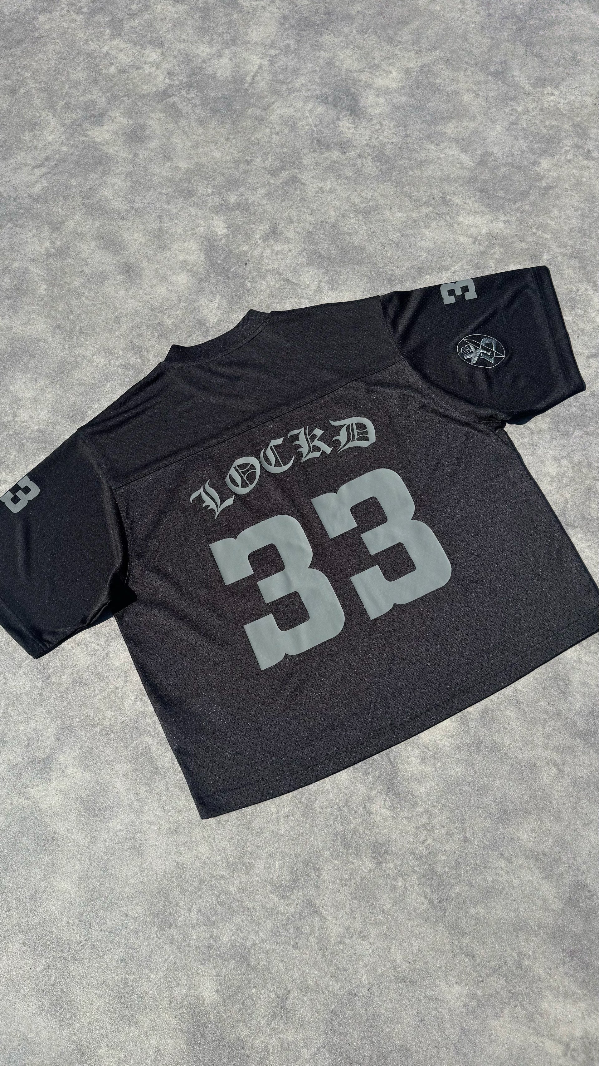 Détail logo brodé LOCKD – maillot oversize noir streetwear